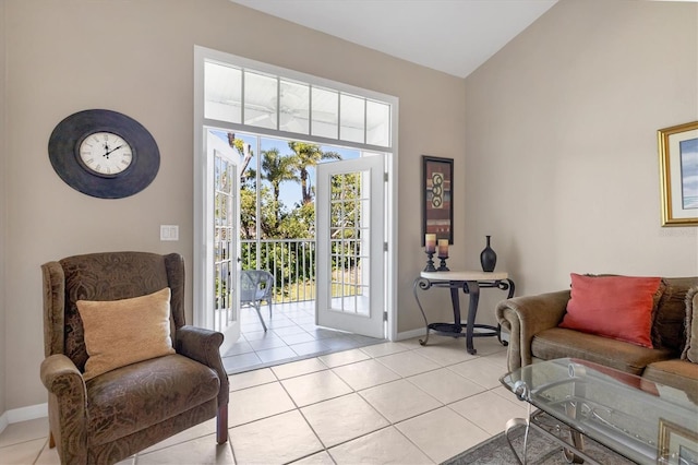 doorway with light tile patterned floors, baseboards, and lofted ceiling