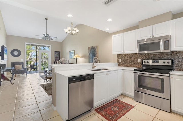 kitchen with open floor plan, stainless steel appliances, decorative backsplash, and a sink