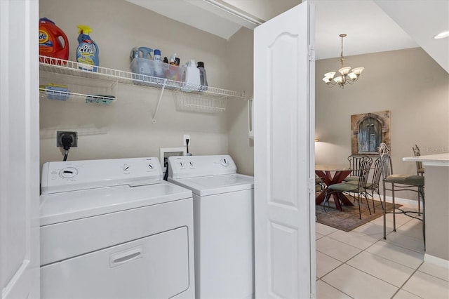 laundry area featuring washer and dryer, an inviting chandelier, light tile patterned flooring, baseboards, and laundry area