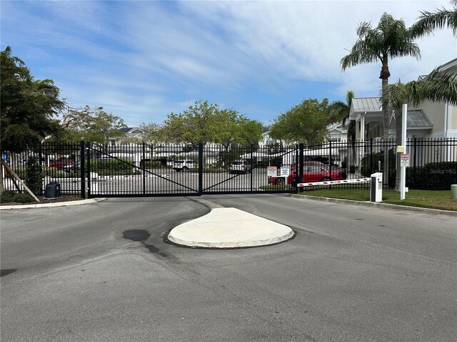 view of road featuring a gate, curbs, and a gated entry