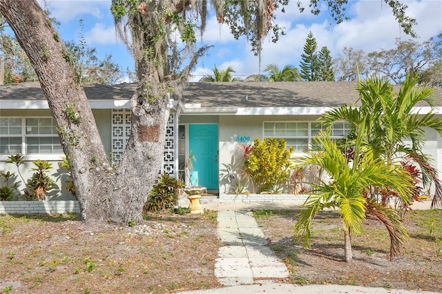 view of front of home featuring roof with shingles and stucco siding