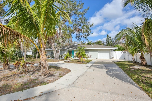 view of front of house featuring an attached garage, fence, driveway, a gate, and stucco siding