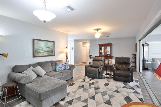 living room featuring baseboards, visible vents, and light wood-style floors