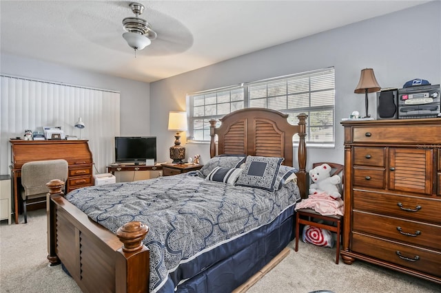 bedroom with a ceiling fan, multiple windows, and carpet flooring