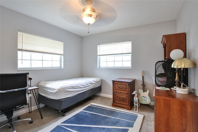 carpeted bedroom featuring ceiling fan, multiple windows, and baseboards