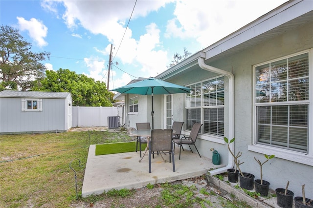 view of yard featuring a patio, an outbuilding, a storage unit, fence, and cooling unit