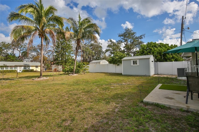 view of yard with a patio area, a fenced backyard, a storage unit, and an outdoor structure