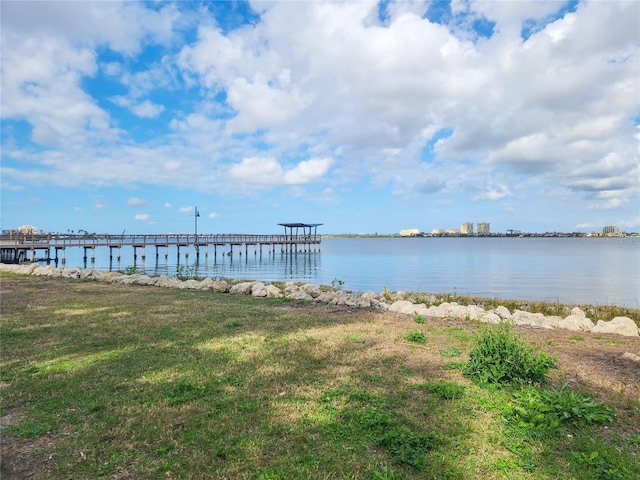 dock area with a lawn and a water view