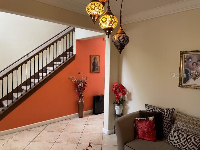 stairs featuring tile patterned floors and ornamental molding