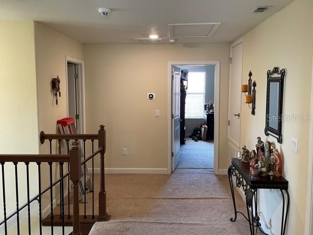 hallway with light colored carpet