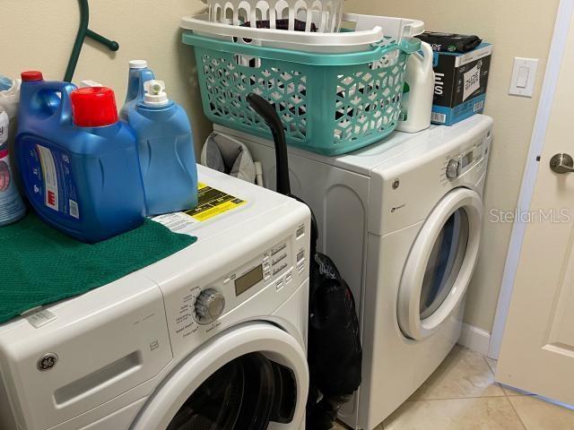 washroom with light tile patterned flooring and washing machine and dryer