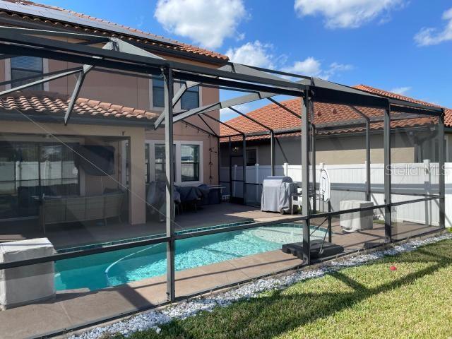 exterior space featuring a lanai, a patio, and a lawn