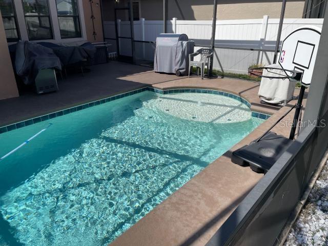 view of swimming pool featuring a grill and a patio