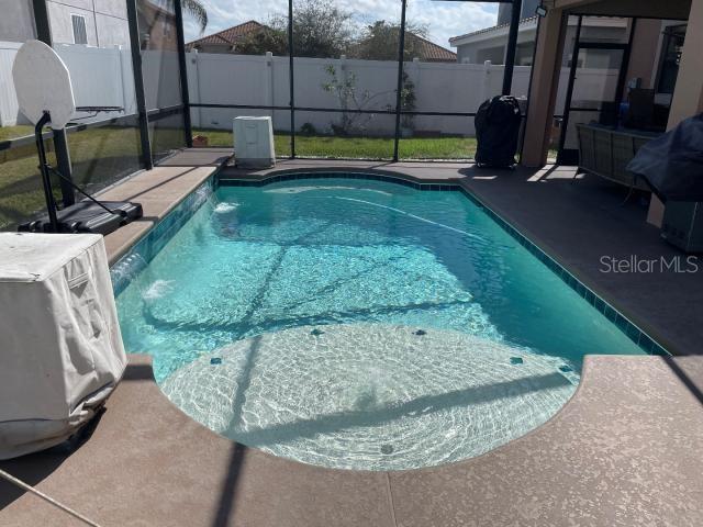 view of pool featuring glass enclosure