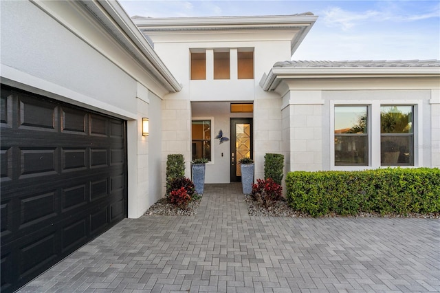 5074 Surfside Cir, Bradenton, FL 34211 - view of exterior entry with a garage, driveway, stucco siding, and concrete block siding