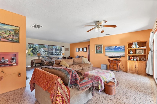 living room with ceiling fan and a textured ceiling