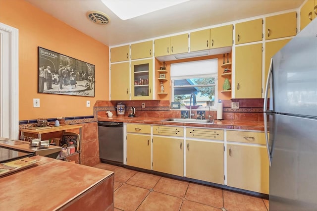 kitchen with stainless steel appliances, sink, and light tile patterned floors