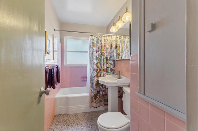 bathroom featuring tile walls, shower / tub combo, and toilet