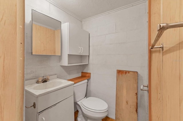 bathroom featuring vanity, crown molding, and toilet