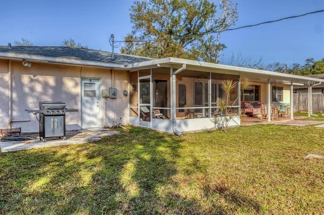 rear view of house with a sunroom and a lawn