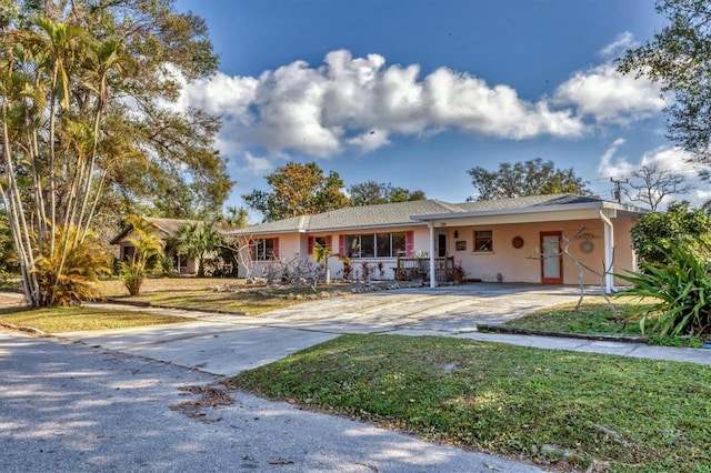 ranch-style house featuring a carport and a front yard