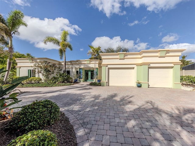 view of front of property featuring a garage, decorative driveway, and stucco siding