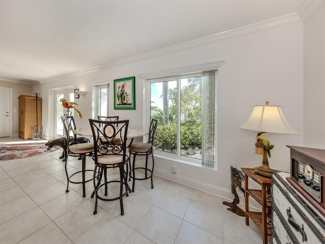 dining space with light tile patterned floors, ornamental molding, and baseboards