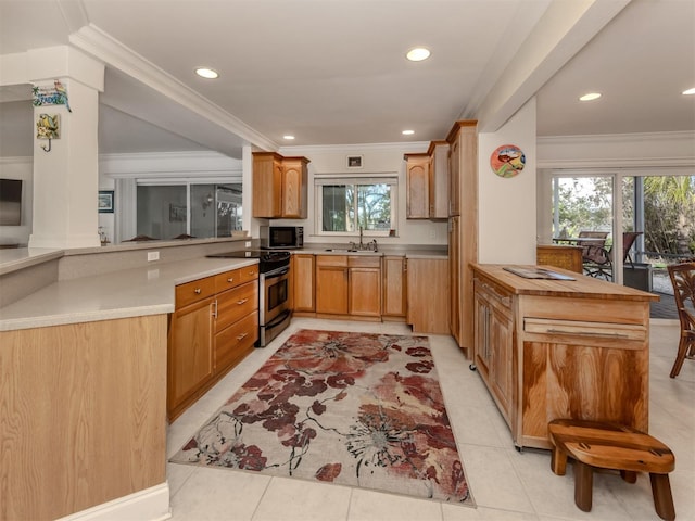 kitchen featuring a peninsula, appliances with stainless steel finishes, light countertops, and a sink