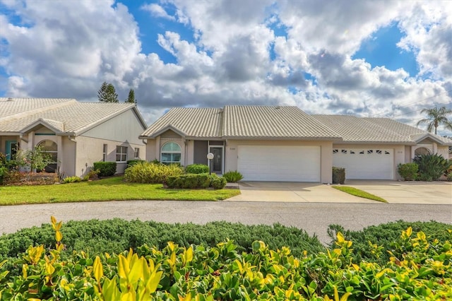 ranch-style home with a garage and a front lawn