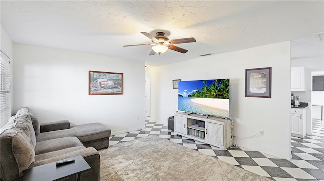 living room featuring a textured ceiling and ceiling fan