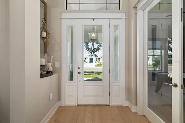 foyer featuring light wood-style flooring and baseboards