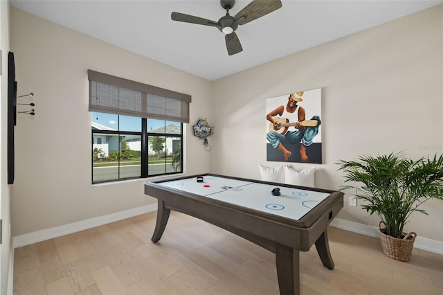 playroom featuring light wood-type flooring, a ceiling fan, and baseboards