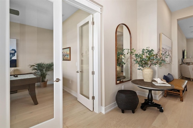 hall with french doors, baseboards, and wood finished floors