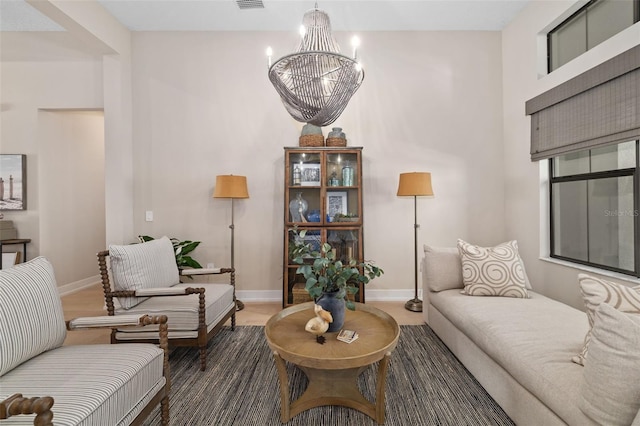 living room with a chandelier, visible vents, and baseboards