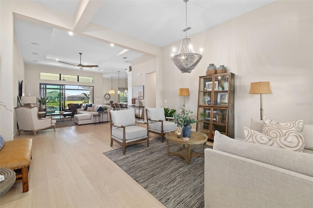 living area with light wood-type flooring and a notable chandelier