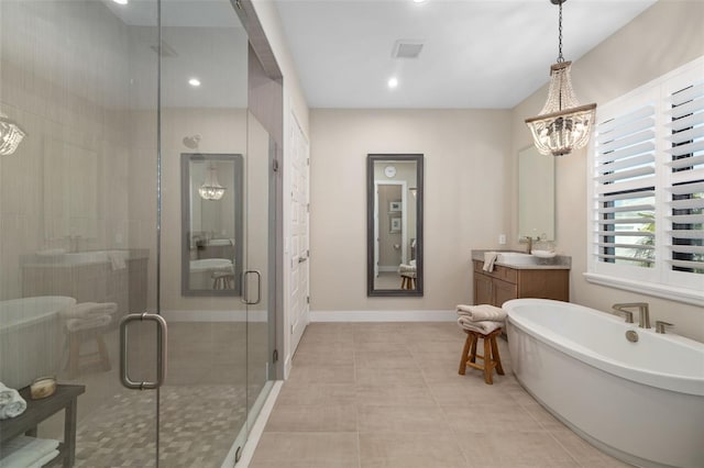 bathroom with a freestanding tub, vanity, baseboards, a shower stall, and tile patterned floors