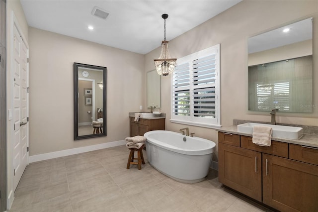 full bath featuring visible vents, baseboards, a soaking tub, a sink, and two vanities