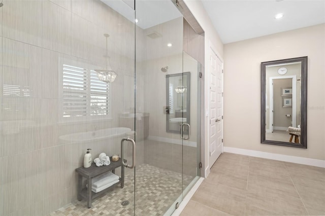 bathroom with baseboards, a shower stall, and tile patterned floors