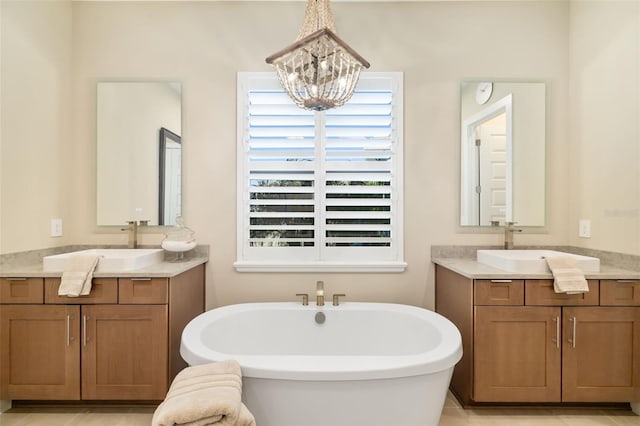 bathroom featuring a freestanding tub, two vanities, and a sink