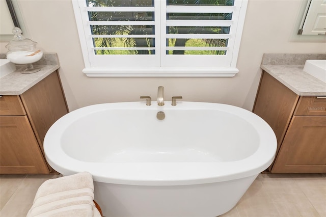 full bath with tile patterned flooring, a soaking tub, plenty of natural light, and vanity