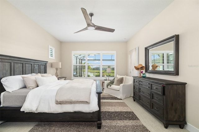 bedroom featuring ceiling fan, multiple windows, baseboards, and light colored carpet