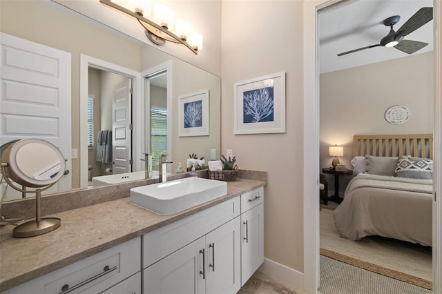 full bath featuring toilet, ensuite bathroom, a ceiling fan, vanity, and baseboards