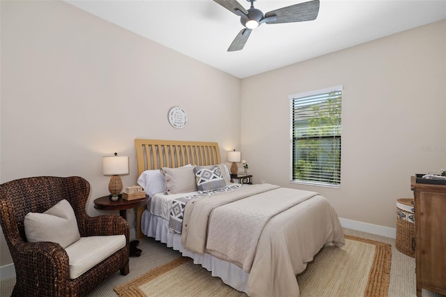 bedroom featuring a ceiling fan, light colored carpet, and baseboards