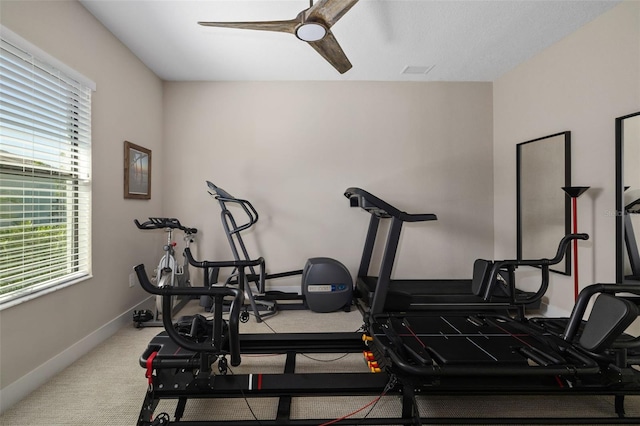 exercise room with a ceiling fan, carpet floors, and baseboards