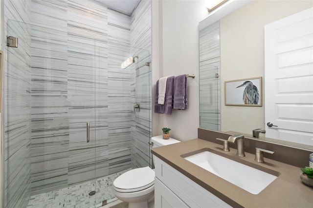 bathroom with a stall shower, vanity, and toilet