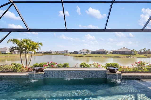 outdoor pool featuring glass enclosure and a water view