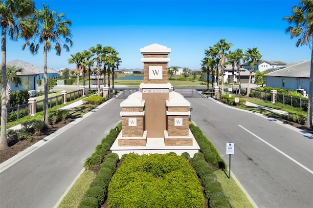 view of street with a residential view, sidewalks, and a gated entry