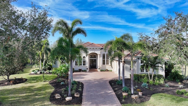 mediterranean / spanish-style house with a front yard and a garage