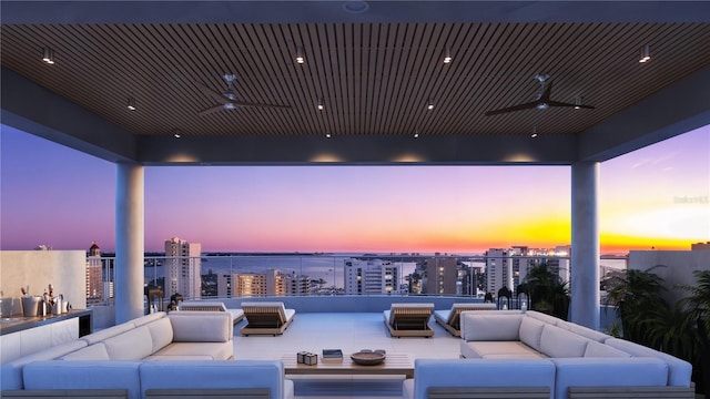 patio terrace at dusk with ceiling fan and an outdoor hangout area