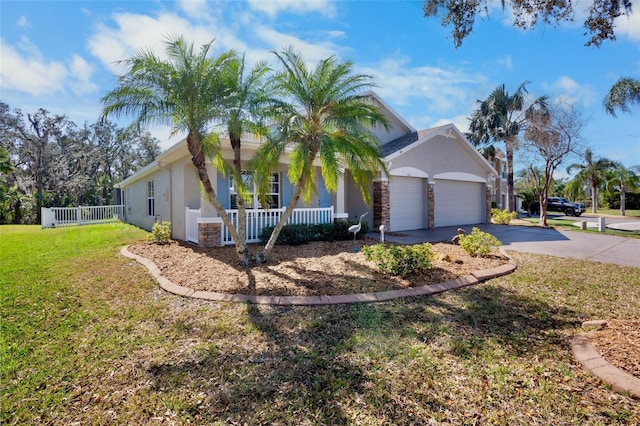 single story home featuring a garage, covered porch, and a front lawn